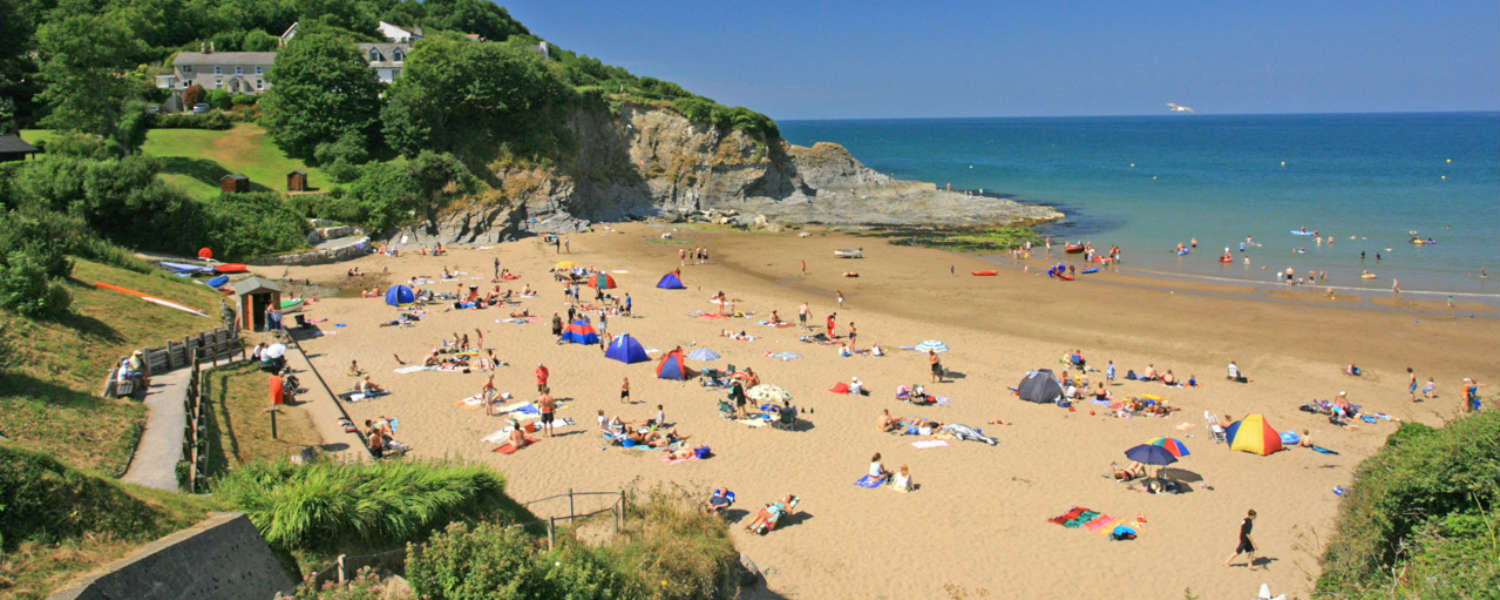 View overlooking golden sand and blue sea at Aberporth beach in the summer