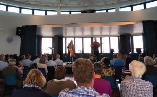 Room of people watching a music performance on stage